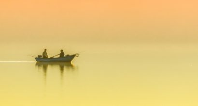 Two persons boat lake fishing mist morning sun