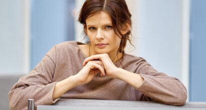 Nanen katsoo kameraan pöydän takaa